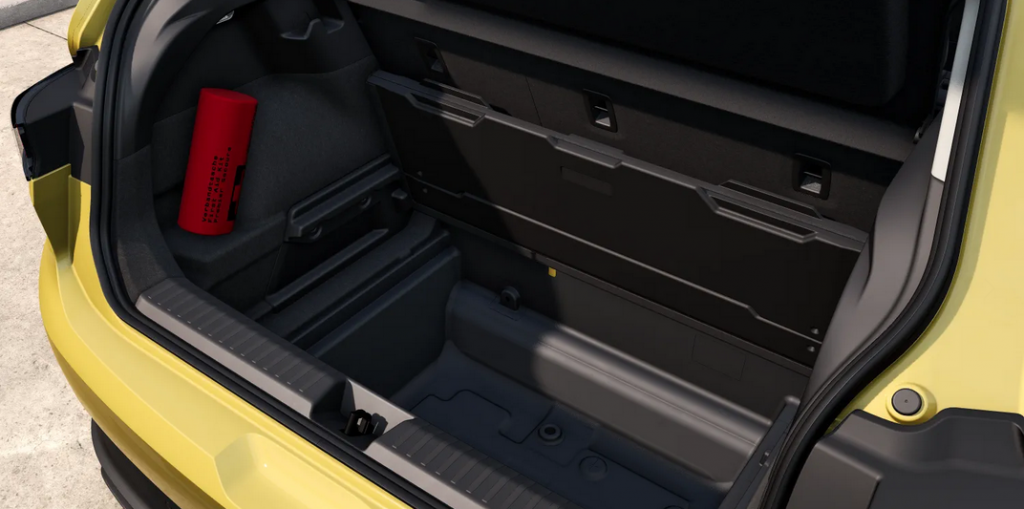 Trunk of a yellow car with a dark interior and a red safety canister mounted on the left side panel.