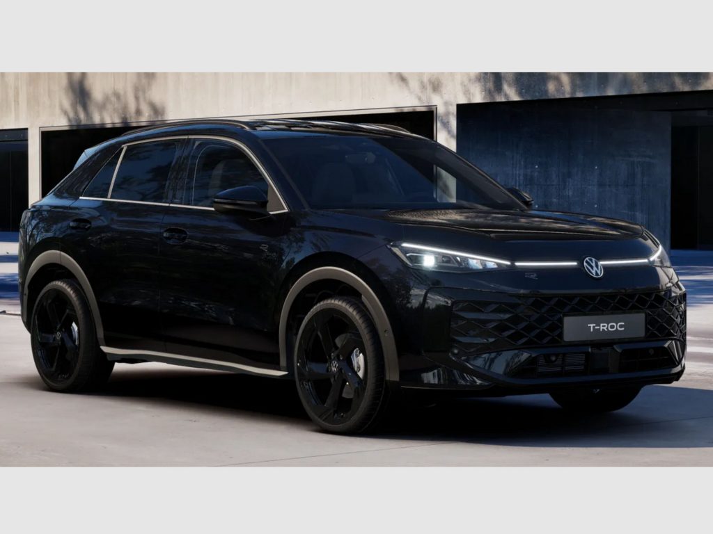 Black Volkswagen T-Roc SUV parked in front of a modern building with dark blue doors behind it? (car in foreground)