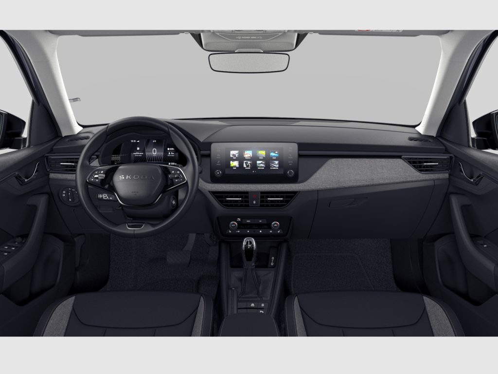 Interior view of a modern Skoda car cockpit showing steering wheel, digital dashboard, and central touchscreen display with controls and vented dashboard features.