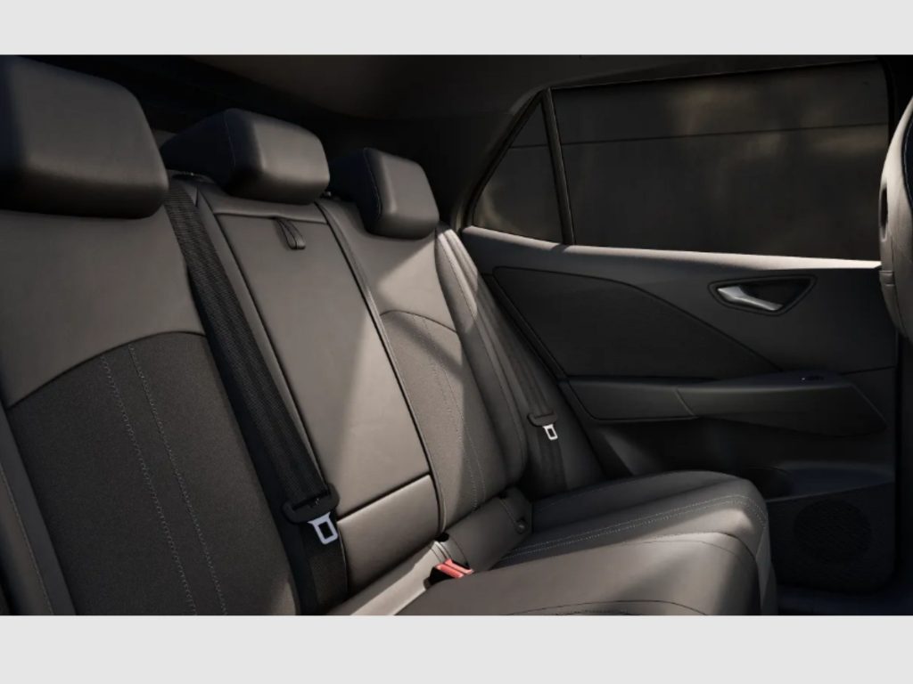 Rear car seats in a dark, leather interior with visible seat belts and door panel details