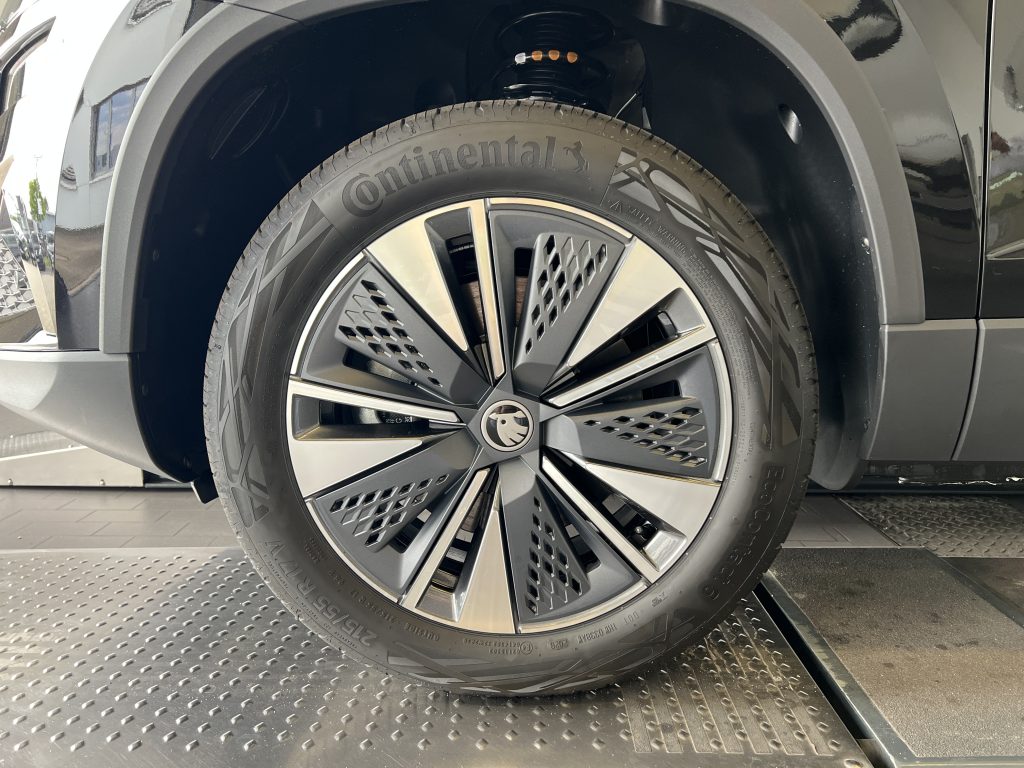 Close-up of a car wheel with a Continental tire and a stylish multi-spoke alloy rim, inside the wheel well.