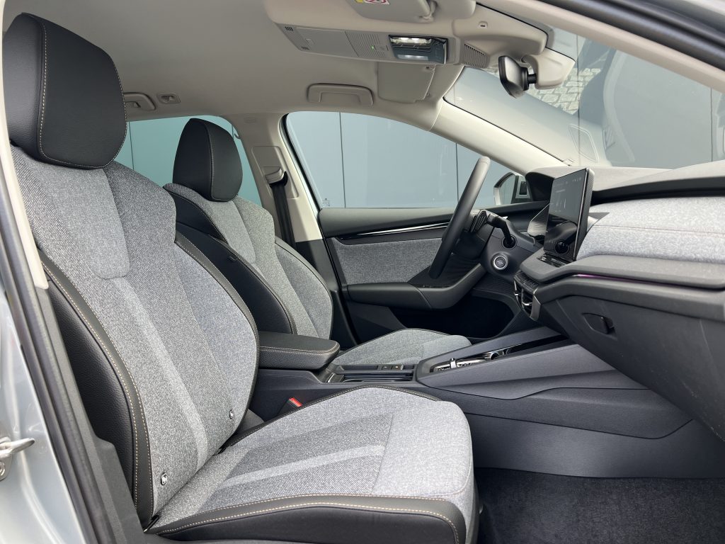Front interior of a car with gray fabric seats, black headrests, and a dashboard touchscreen.