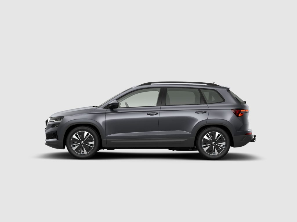 Partial side view of a gray SUV with roof rails against a light backdrop.