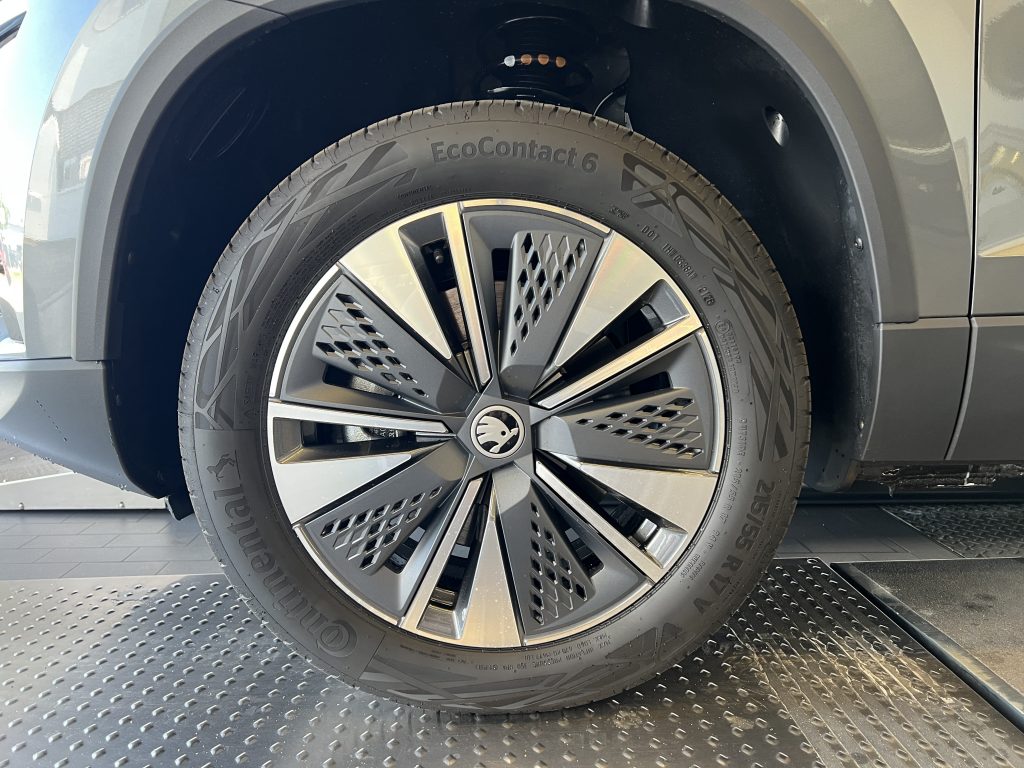 Close-up of a car wheel with an EcoContact 6 tire and modern alloy rim, mounted in a showroom setting