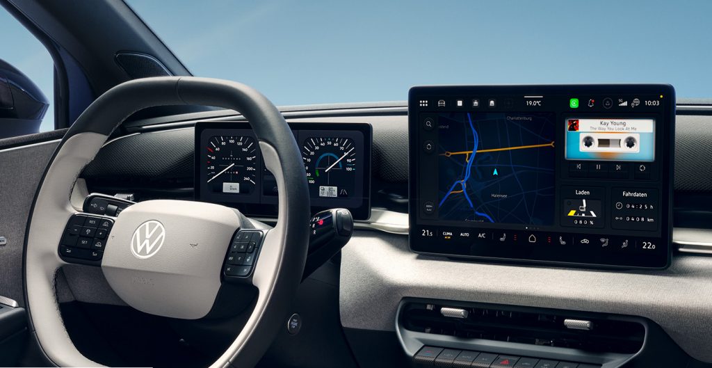 VW interior with a large touchscreen map, steering wheel, and the slogan 'Mehr Raum. Mehr Komfort.' across the windshield