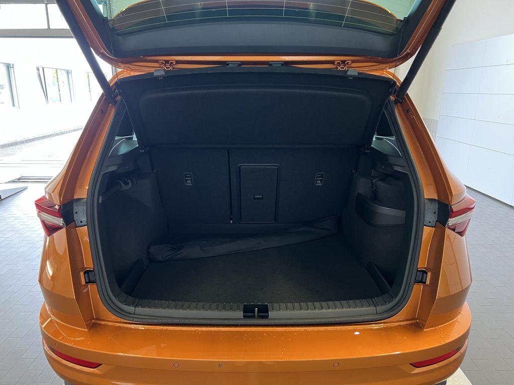 Open orange SUV trunk showing a spacious cargo area with rear seats upright.