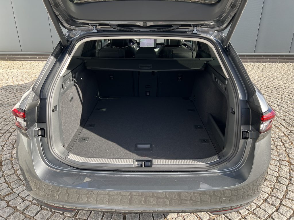 Open hatchback showing a spacious cargo area with folded rear seatbacks and headrests visible in the background, SUV interior.