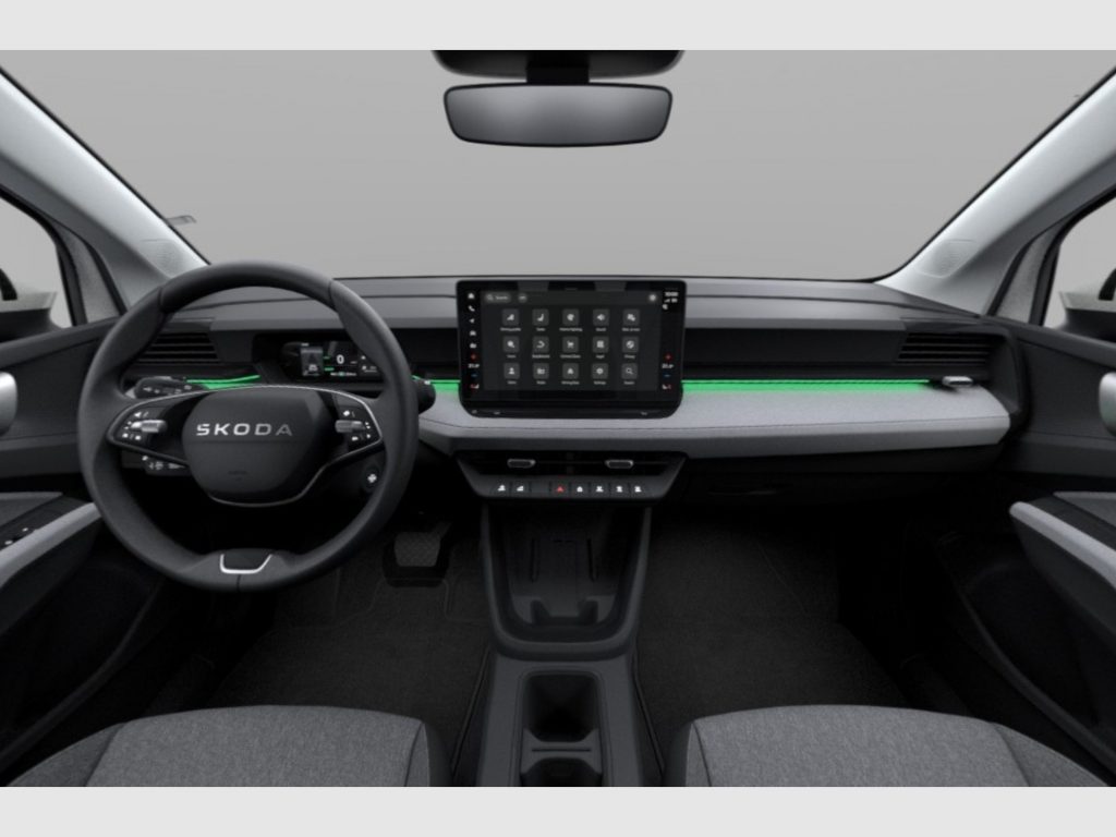 Interior view of a Skoda car cockpit with steering wheel, large central touchscreen, and dashboard controls from the driver’s perspective