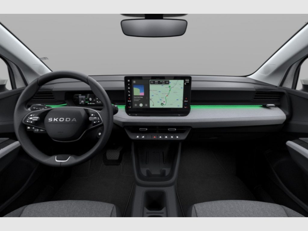 Driver's view of a Škoda interior with a large vertical touchscreen navigation display in the center, steering wheel on the left, gray dashboard, and black seats.