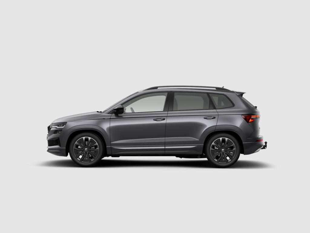 Side view of a gray SUV with roof rails and alloy wheels against a light gray backdrop.