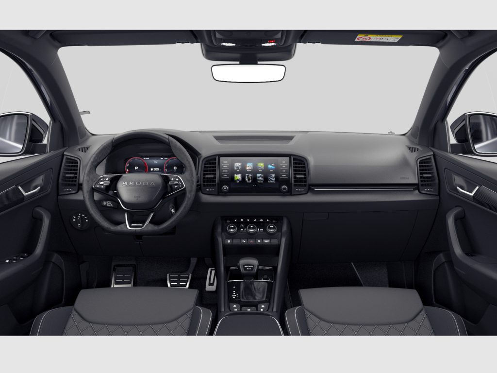 Front interior of a modern SUV showing steering wheel, dashboard touchscreen, center console, and rearview mirror (driving cockpit).