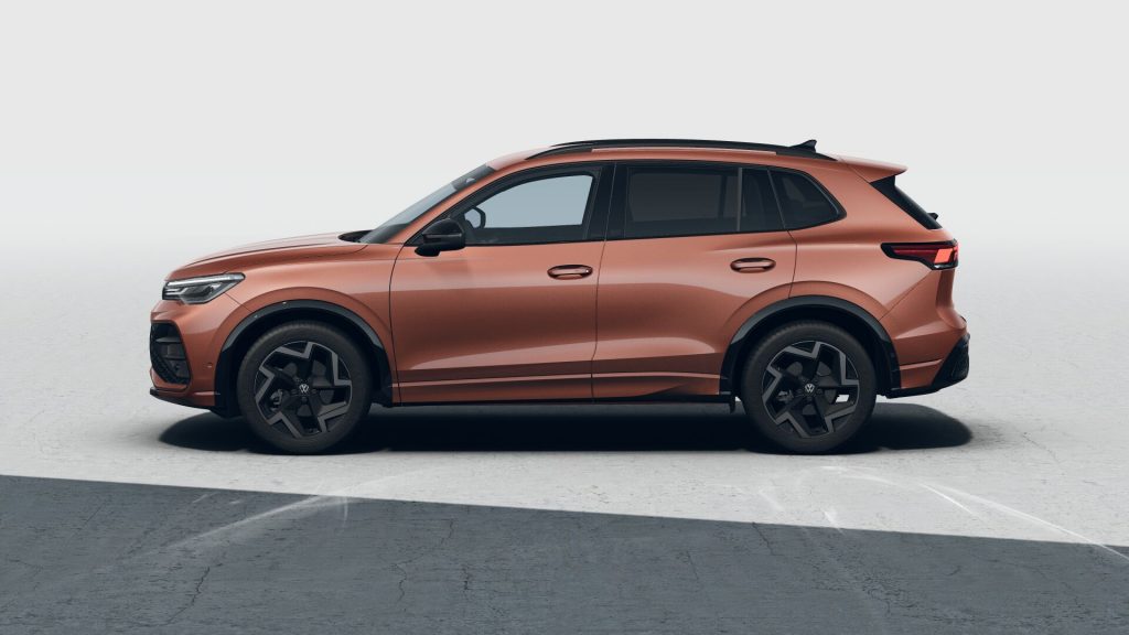 Side profile of a copper-colored SUV with black wheels and roof rails parked on a concrete surface.