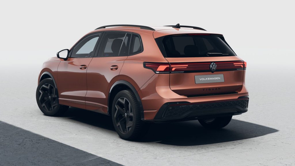 Copper-colored VW Tiguan SUV seen from the rear-left, showing the taillights and Volkswagen badge against a pale background