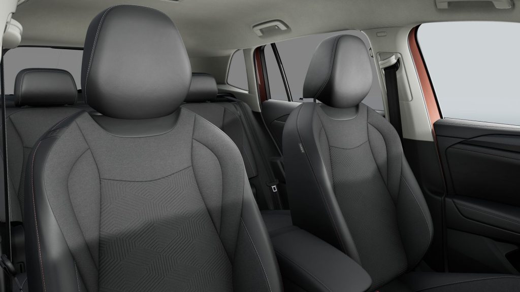 Interior of a modern car showing front seats with gray fabric and red stitching