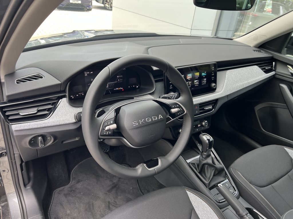 Driver’s cockpit of a Skoda with digital instrument cluster and large touchscreen infotainment system.